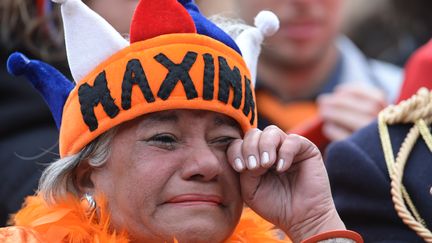 Une dame, &eacute;mue, pleure pendant la c&eacute;r&eacute;monie d'abdication de la reine Beatrix, retransmis sur &eacute;cran g&eacute;ant, place du Dam, &agrave; Amsterdam, le 30 avril 2013.&nbsp; (PATRIK STOLLARZ / AFP)