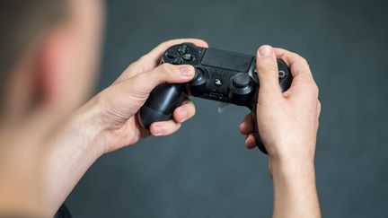 Une personne joue à la&nbsp;console à Stuttgart (Allemagne), le 26 septembre 2017. (SEBASTIAN GOLLNOW / DPA / AFP)