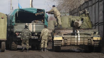 Des soldats ukrainiens charges des armes lourdes dans des camions, pr&egrave;s de Donetsk, dans l'Est de l'Ukraine, vendredi 6 mars 2015. (VIKTOR KOSHKIN / ANADOLU AGENCY / AFP)