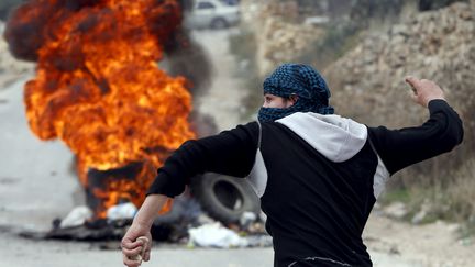 Un Palestinien&nbsp;jette&nbsp;des pierres sur les troupes israéliennes durant des affrontements dans la ville d'Hébron, en Cisjordanie, le 6 novembre 2015.&nbsp; (MUSSA QAWASMA / REUTERS)