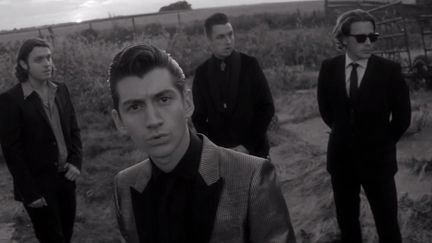 Les Arctic Monkeys (Alex Turner au centre).
 (Saisie écran du clip &quot;One for the road&quot;)