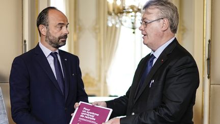 Jean-Paul Delevoye (à droite) lors de la remise de son rapport au Premier ministre, le 18 juillet 2019 (KENZO TRIBOUILLARD / AFP)