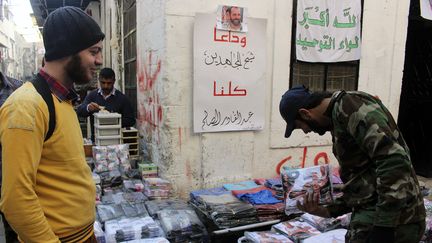 Stand de v&ecirc;tements tenu par l'Arm&eacute;e syrienne libre &agrave; Alep (Syrie), le 21 novembre 2013. Accroch&eacute;e au mur, une photo&nbsp;d'Abdel Qader Saleh, tu&eacute; trois jours plus t&ocirc;t dans un raid a&eacute;rien des forces de Bachar&nbsp;Al-Assad. (MOLHEM BARAKAT / REUTERS)