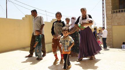 Des irakiens de la minorit&eacute; Yezidi fuient leur ville de Sinjar, le 4 ao&ucirc;t, avant l'arriv&eacute;e des jihadistes. La majorit&eacute; d'entre eux a gagn&eacute; une montagne voisine, o&ugrave; 40 enfants sont morts deshydrat&eacute;s ces derniers jours. (STRINGER IRAQ / REUTERS)