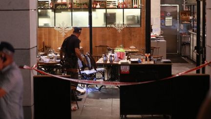 Des policiers examinent la salle de restaurant de Tel Aviv (Israël), où une fusillade a fait quatre morts, le 8 juin 2016. (NURPHOTO / AFP)