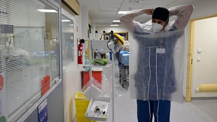 Un&nbsp;soignant met des vêtements de protection avant de soigner&nbsp;des patients infectés par le Covid-19, à&nbsp;l'hôpital de la Timone à Marseille, le 5 janvier 2022. Photo d'illustration. (NICOLAS TUCAT / AFP)