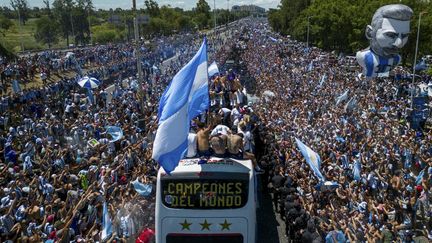 Le bus des champions du monde argentins traversant la foule des supporters autour de Buenos Aires, le 20 décembre 2022. (TOMAS CUESTA / AFP)