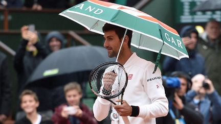 Le joueur serbe Novak Djokovic se promène sur le court avant la reprise de son match contre l'Espagnol Roberto Bautista-Agut, lors du tournoi de&nbsp;Roland-Garros, à Paris, le 31 mai 2016. (ERIC FEFERBERG / AFP)