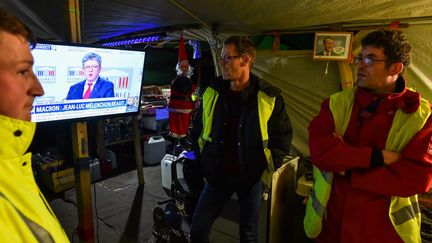 Des "gilets jaunes" écoutent la réaction de Jean-Luc Mélenchon à l'allocution télévisée d'Emmanuel Macron, le 10 décembre 2018. (JEAN-FRANCOIS MONIER / AFP)