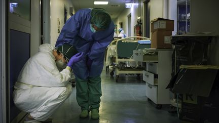 Le personnel soignant est harassé par la tâche immense. Une infirmière en réconforte une autre dans les couloirs de l'hôpital de Crémone (Italie), le 13 mars 2020. (PAOLO MIRANDA / AFP)