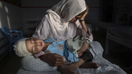 Vie quotidienne, premier prix.&nbsp;
Dans cette photo de Paula Bronstein intitulée "Les victimes silencieuses d'une guerre oubliée", Najiba tient dans ses bras son neveu Shabir, âgé de deux ans. Shabir a été blessé par l'explosion d'une bombe à Kaboul, le 29 mars 2016.&nbsp; (PAULA BRONSTEIN/AP/SIPA / AP)