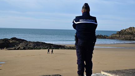 Un gendarme surveille la plage de Saint-Lunaire (Ille-et-Vilaine), le 17 mars 2020. (DAMIEN MEYER / AFP)