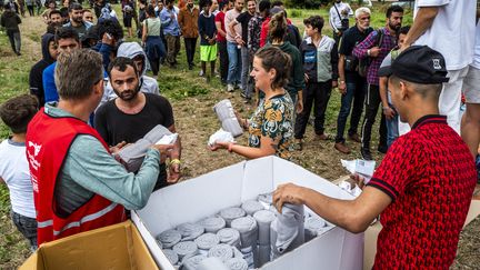 Des membres de l'organisation humanitaire distribuent des couvertures et des kits d'hygiène aux demandeurs d'asile au centre de demande d'asile  de Ter Apel, aux Pays-Bas,le 26 août 2022. (VINCENT JANNINK / ANP)