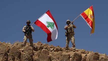 Des soldats libanais hissent le drapeau espagnol sur une colline reprise à l'Etat islamique, le 19 août 2017 à Ras Baalbek (Liban). (LEBANESE ARMY WEBSITE / AFP)