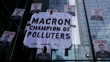 Des affiches collées par des&nbsp;militants écologistes à La Défense, le 19 avril 2019, dans le cadre d'une action de "désobéissance civile" pour le climat. (THOMAS SAMSON / AFP)