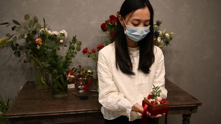 Elise, fleuriste en train de préparer un bouquet pour une famille de détenus à Hong Kong. (PETER PARKS / AFP)