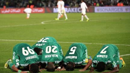 Mohsine Moutaouali&nbsp;(2e D) du&nbsp;Raja Casablanca prie en compagnie de quelques uns autres joueurs du club apr&egrave;s avoir marqu&eacute; un but en finale du Mondial des clubs 2013 face aux Br&eacute;siliens de&nbsp;l'Atletico Mineiro &agrave; Marrakech (Maroc), le 18 d&eacute;cembre 2013. (AMR DALSH / REUTERS)