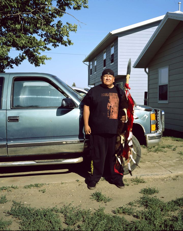 Bruno Serralongue. Gil Kills Pretty Enemy III devant sa maison posant avec ses armes, McLauglin, Dakota du Sud, 21 août 2017, série Les gardiens de l’eau (Water Protectors), 2017 (Bruno Serralongue)