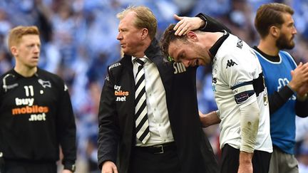 Steve McClaren, réconfortant ses joueurs à l'issue du barrage contre QPR. (BEN STANSALL / AFP)