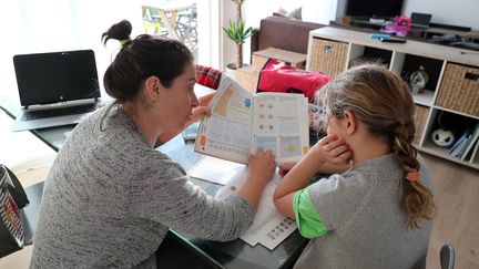 L'école se fait à la maison pendant le confinement et les devoirs des enfants sont la plupart du temps supervisés par les mères (photo d'illustration). (LAURENT THEILLET / MAXPPP)