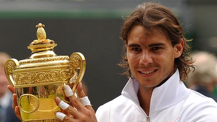 Deuxième titre sur le gazon londonien pour Rafael Nadal, qui ne laisse que des miettes a ses adversaires. Il décroche son second Grand Chelem de l'année en écartant le Tchèque Tomas Berdych, le 4 juillet 2010 (6-3, 7-5, 6-4). (ADRIAN DENNIS / AFP)