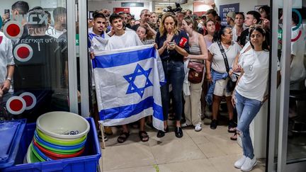 Des personnes sont rassemblées à l'entrée du centre médical de Tel-HaShomer (Israël), où sont hospitalisés les quatre ex-otages libérés par l'armée israélienne, le 8 juin 2024. (JACK GUEZ / AFP)