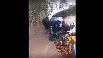 Les trois agriculteurs ont dû fabriquer un pont de fortune pour atteindre le véhicule qui s'enfonçait. (Vidéo filmée par un habitant et diffusée sur les réseaux sociaux) (Capture d'écran)