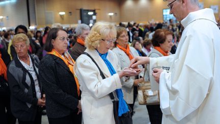 Des catholiques communient lors d'une messe, le 14 octobre 2012, &agrave; Lyon (Rh&ocirc;ne).&nbsp; (PHILIPPE MERLE / AFP)