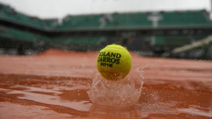 Une balle de tennis rebondit dans la pluie parisienne, à Roland-Garros (Paris), le 31 mai 2016. (MARTIN BUREAU / AFP)