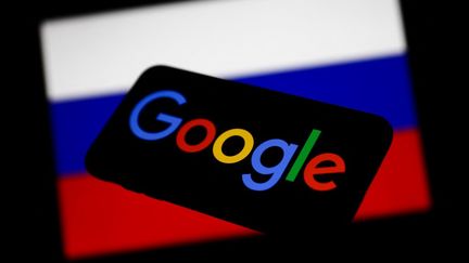 Le logo de Google devant le drapeau russe, le 1er mars 2022. (JAKUB PORZYCKI / NURPHOTO / AFP)