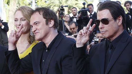 En 2014, Quentin Tarantino vient à Cannes pour fêter les 20 ans de Pulp Fiction. Pour cette projection spéciale, il est accompagné par deux acteurs du film : Uma Thurman et John Travolta. (VALERY HACHE / AFP)