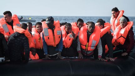 Des migrants équipés de gilets de sauvetage transférés sur "l'Aquarius", aux abords des côtes lybiennes, le 12 mai 2018. (LOUISA GOULIAMAKI / AFP)