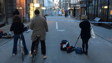 Deux cyclistes se tiennent devant une rue barrée, dans le centre-ville de&nbsp;Stockholm (Suède), le 7 avril 2017. (REUTERS)