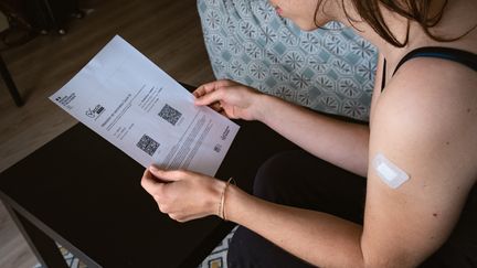 Une femme en possession de son certificat de vaccination après avoir reçu une injection de vaccin contre le Covid-19, à Paris, le 21 mai 2021. (LEO PIERRE / HANS LUCAS / AFP)