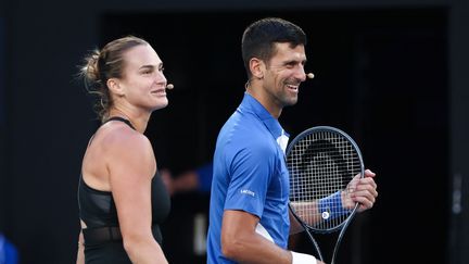 La Biélorusse Aryna Sabalenka et le Serbe Novak Djokovic jouent ensemble en double mixte lors d'un événement caritatif à la Rod Laver Arena de Melbourne, le 11 janvier 2024, avant le début de l'Open d'Australie. (DAVID GRAY / AFP)