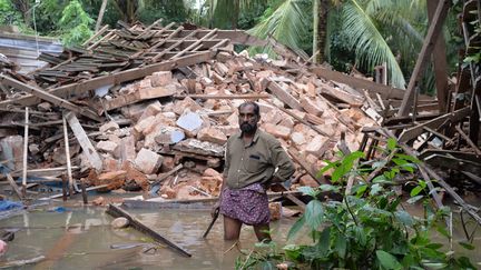 Ajith Prasad, un homme de 54 ans, se tient devant les décombres de sa maison dans l'Etat du Kerala en Inde, le 17 août 2018.&nbsp; (MANJUNATH KIRAN / AFP)