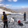 Xavier Cointeaux, coprésident du bureau des guides de La Grave, en compagnie de deux techniciens calculant la fonte glaciaire, le 10 août sur le glacier de la Girose (Hautes-Alpes). (PAOLO PHILIPPE / FRANCEINFO)