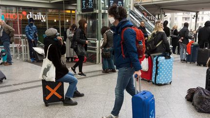 Des personnes s'apprêtent à prendre le train à la gare de Lyon à Paris, le 17 mars 2020, premier jour du confinement. (MASHA MOSCONI / HANS LUCAS / AFP)