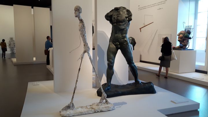 "L'Homme qui marche" d'Alberto Giacometti (à gauche) et "L'Homme qui marche" d'Auguste Rodin (à droite), &nbsp;exposés au Grand Palais, à Paris, du 22 mars au 31 juillet 2017 (ANNE CHEPEAU / RADIO FRANCE)