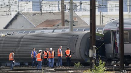 Les enquêteurs après le déraillement du train Paris-Limoges, à Brétigny-sur-Orge (Essonne), en 2013. (KENZO TRIBOUILLARD / AFP)