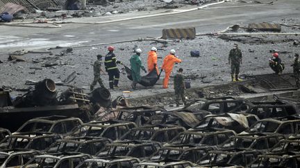 Des secouristes &eacute;vacuent un corps du port de Tianjin (Chine), le 14 ao&ucirc;t 2015, apr&egrave;s une s&eacute;rie d'explosions. (JASON LEE / REUTERS)