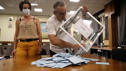 Des assesseurs dépouillent les premiers bulletins, le 10 avril 2022 à La Possession (La Réunion). (RICHARD BOUHET / AFP)