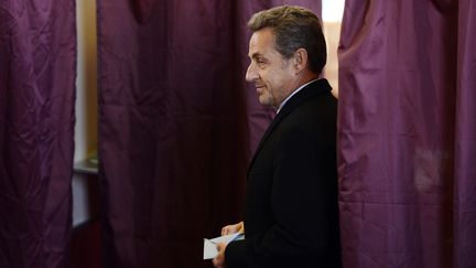 Nicolas Sarkozy dans un bureau de vote, pour le premier tour des&nbsp;&eacute;lections municipales, le 23 mars 2014, &agrave; Paris. (ERIC FEFERBERG / AFP)