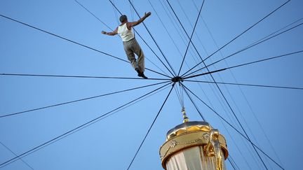 Jean Dujardin, star de la cérémonie d'ouverture, envoyé dans les airs au Stade de France pour s'approcher de la réplique de la Coupe Webb Ellis. (ANNE-CHRISTINE POUJOULAT / AFP)