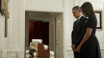 Barack Obama et son &eacute;pouse Michelle observent une minute de silence&nbsp;en hommage aux 26 victimes, dont 20 enfants, de la fusillade de l'&eacute;cole Sandy Hook de Newtown, &agrave; la Maison Blanche, &agrave; Washington (Etats-Unis), le 14 d&eacute;cembre 2013. (SAUL LOEB / AFP)