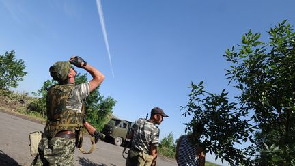 Des rebelles pro-russes observent des avions de l'arm&eacute;e ukrainienne qui survolent la ville de Marynivka, pr&egrave;s de Donetsk, dans l'est de l'Ukraine, mercredi 16 juillet 2014.&nbsp; (DOMINIQUE FAGET / AFP)