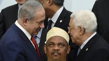 Le Premier ministre israélien Benyamin Nétanyahou, et le président de l'Autorité palestinienne, Mahmoud Abbas, lors de la COP21 à Paris, le 30 novembre 2015. (MARTIN BUREAU / AFP)