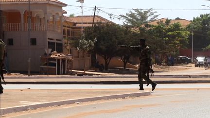 Un homme armé devant le palais du gouvernement de Guinée-Bissau, le 2 février à Bissau. (AFPTV TEAMS / AFP)