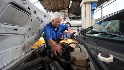 Un sénior travaille dans un garage automobile à Hérouville-Saint-Clair (Calvados). (MYCHELE DANIAU / AFP)