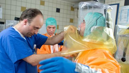 Des scientifiques allemands se livrent &agrave; un exercice de simulation pour se pr&eacute;parer &agrave; une &eacute;ventuelle &eacute;pid&eacute;mie d'Ebola, le 5 ao&ucirc;t 2014 &agrave; Francfort. (BORIS ROESSLER / DPA / AFP)